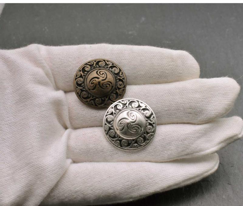 Keltischer Knopf mit Triskele auf der Hand